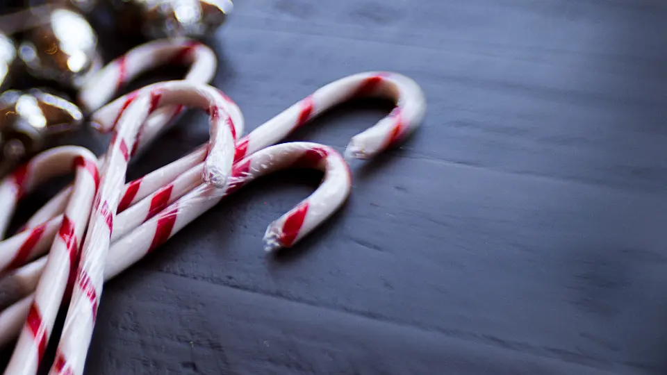 Juleklubbor och små klockor på ett mörkt bord